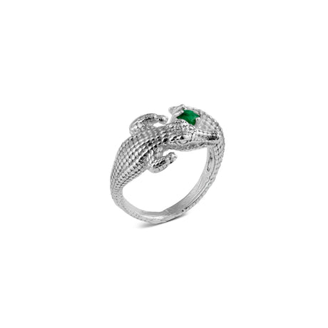 A silver ring with an alligator design wrapped around the finger and set with a green emerald.