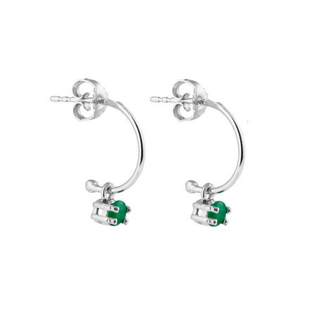 A pair of silver hoop earrings with emerald gemstones attached to the hoop, perfect for layerig