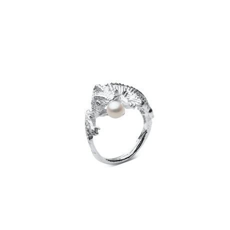 This sculptural chameleon ring is set with a luminous pearl, symbolizing transformation and quiet power. Handcrafted in Stockholm, it’s a bold statement piece with refined elegance.