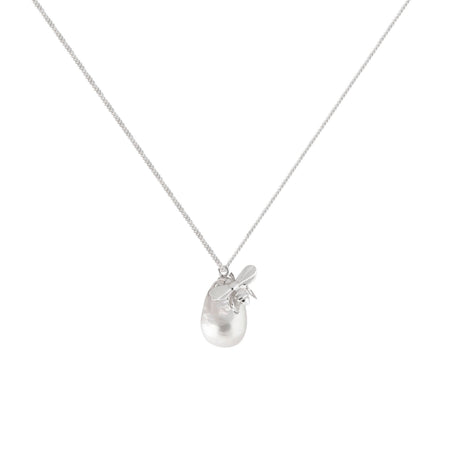 A silver necklace with a sculpted bee design climbing on top of a baroque pearl, suspended on a chain.